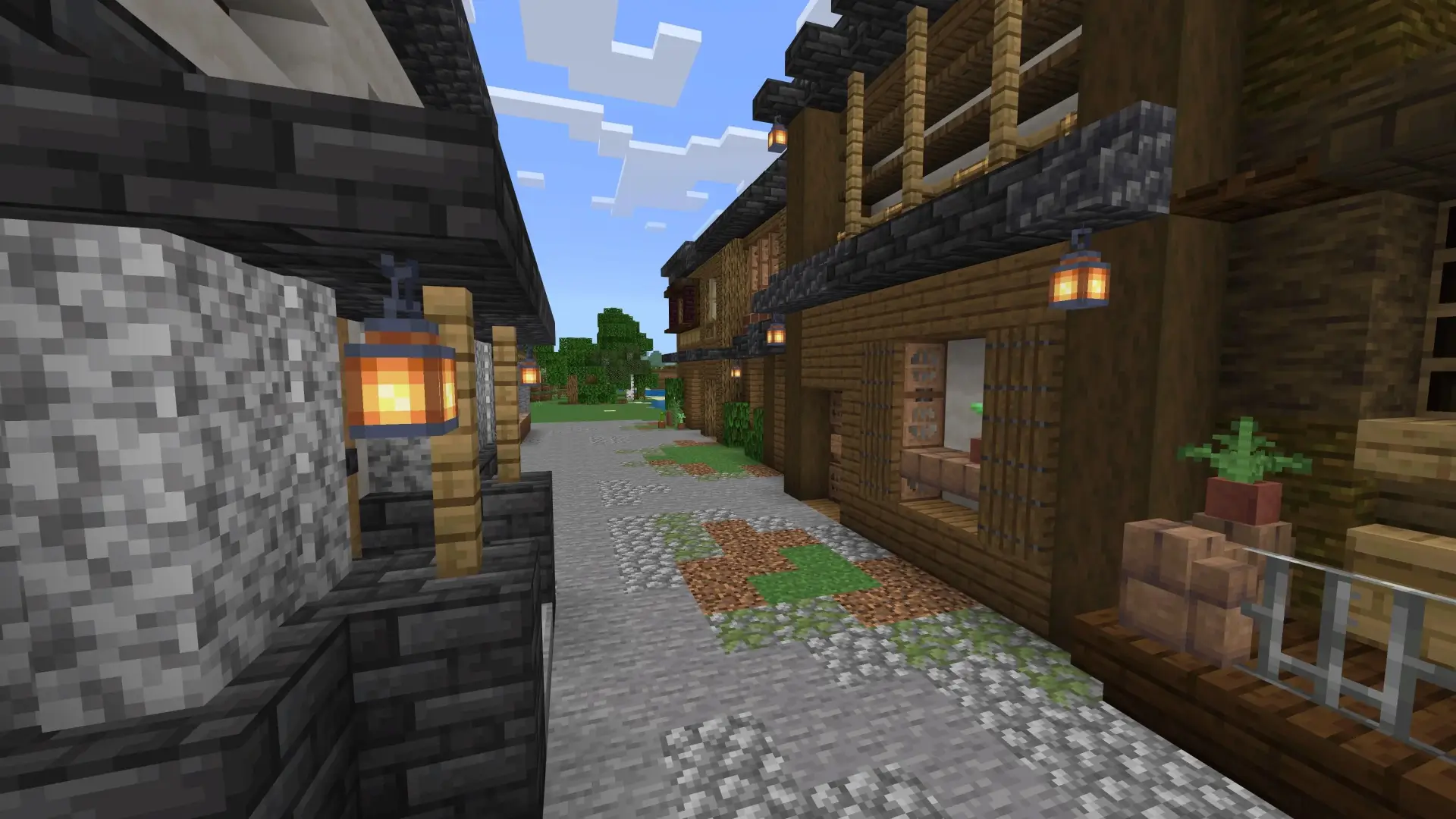 Calle de pueblo japones tradicional en Minecraft con casas japonesas de piedra y madera, decorada con macetas y detalles rústicos.