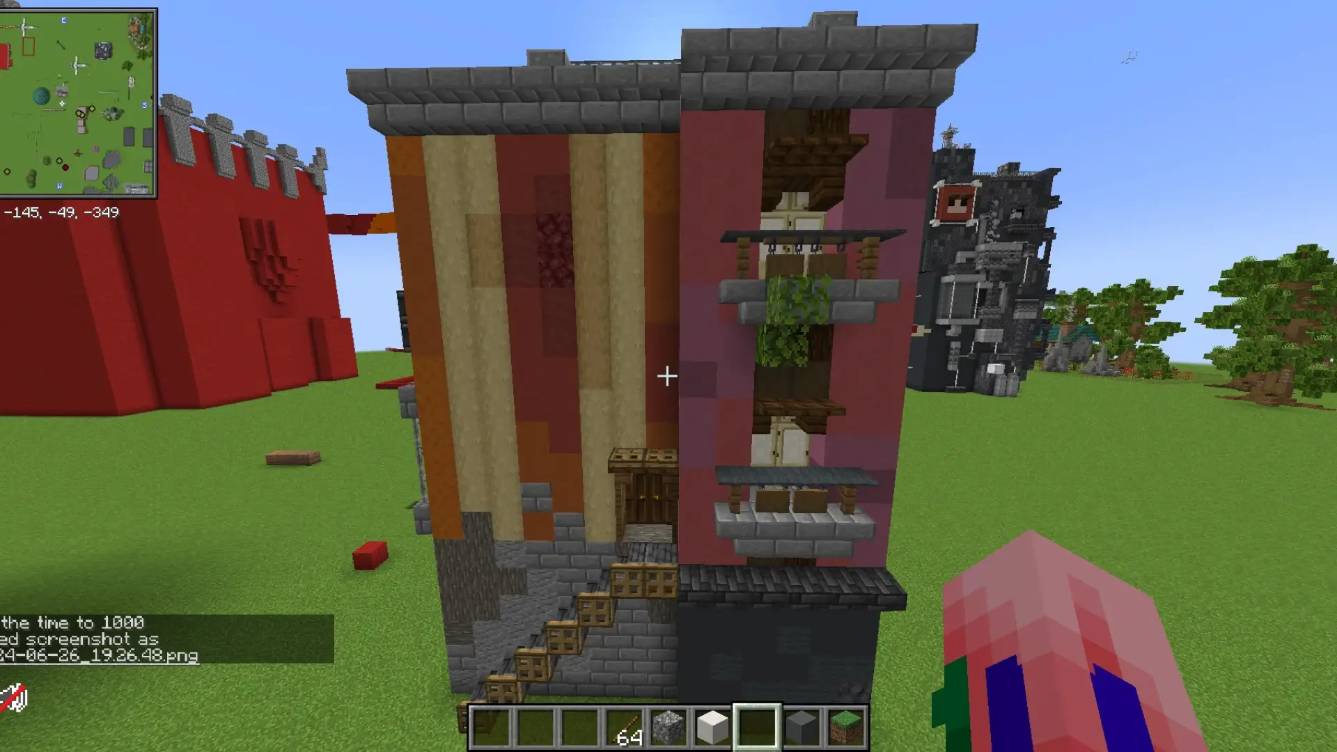 Imagen de un edificio de apartamentos en Minecraft con fachada en tonos naranjas y rosas, balcones, y un negocio en la planta baja.