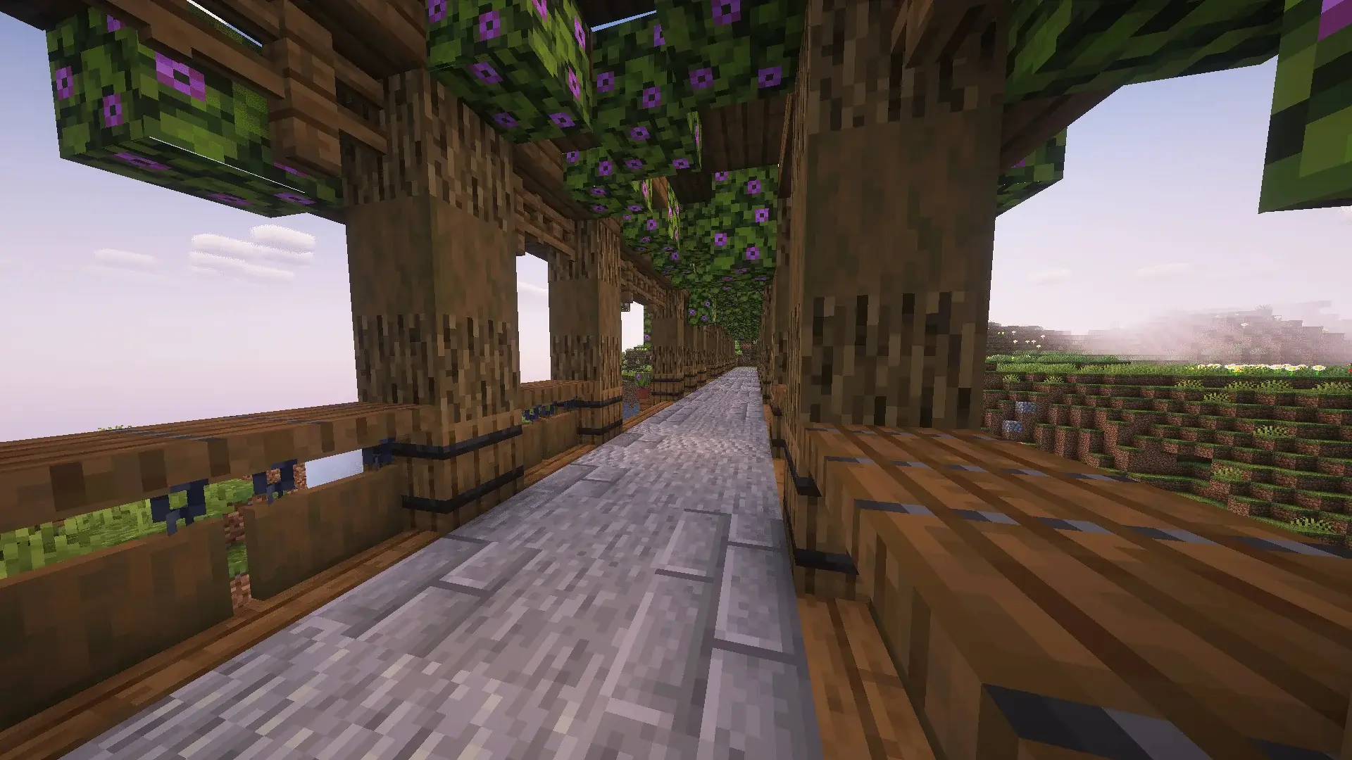 Puente de madera en Minecraft atravesando un cañón, con soportes arqueados, linternas colgantes y decoraciones de plantas y flores.