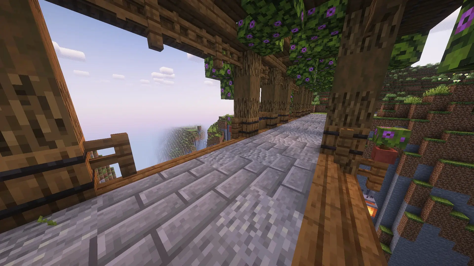 Puente de madera en Minecraft atravesando un cañón, con soportes arqueados, linternas colgantes y decoraciones de plantas y flores.