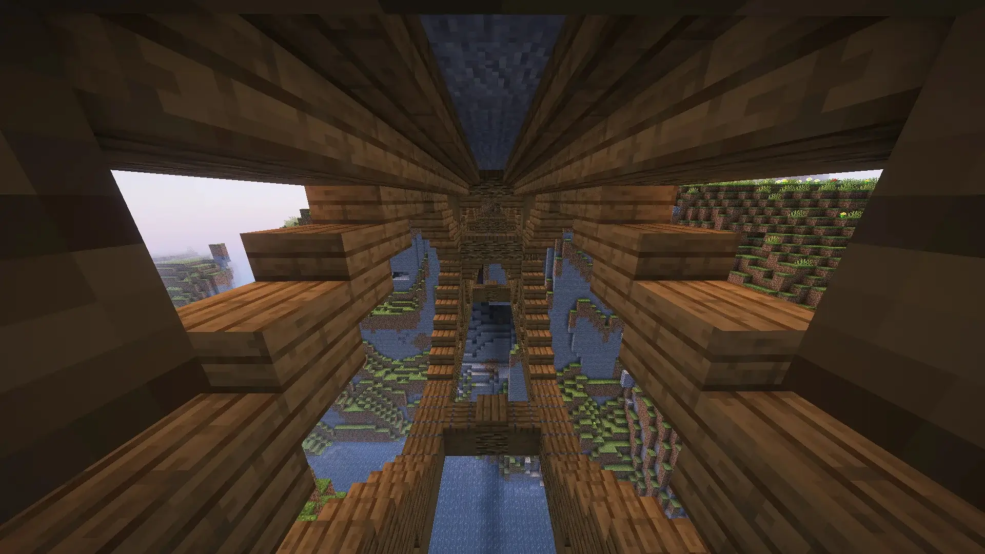 Puente de madera en Minecraft atravesando un cañón, con soportes arqueados, linternas colgantes y decoraciones de plantas y flores.